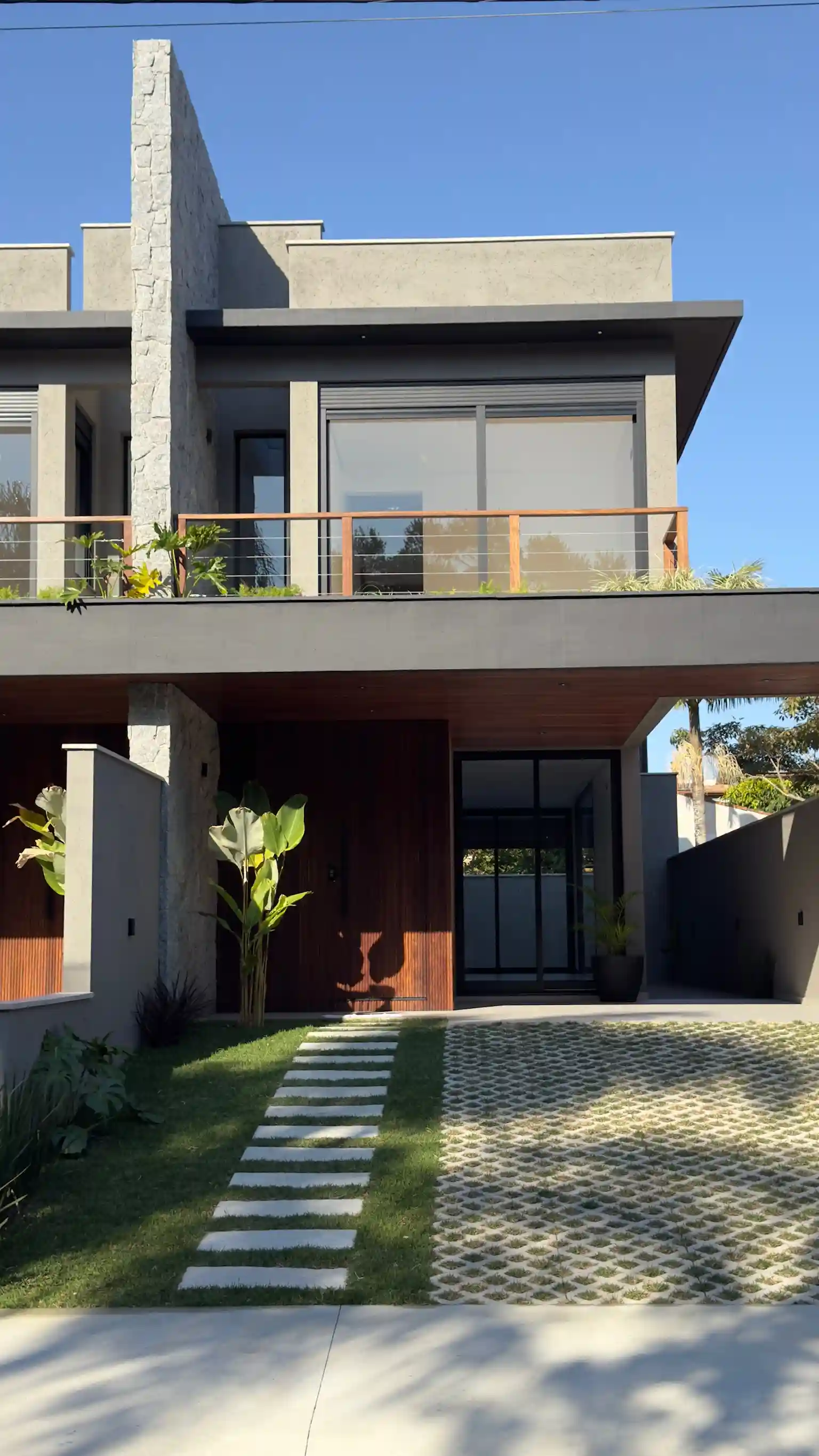 Timber entrance and landscaped exterior of a completed home in southern Florianópolis