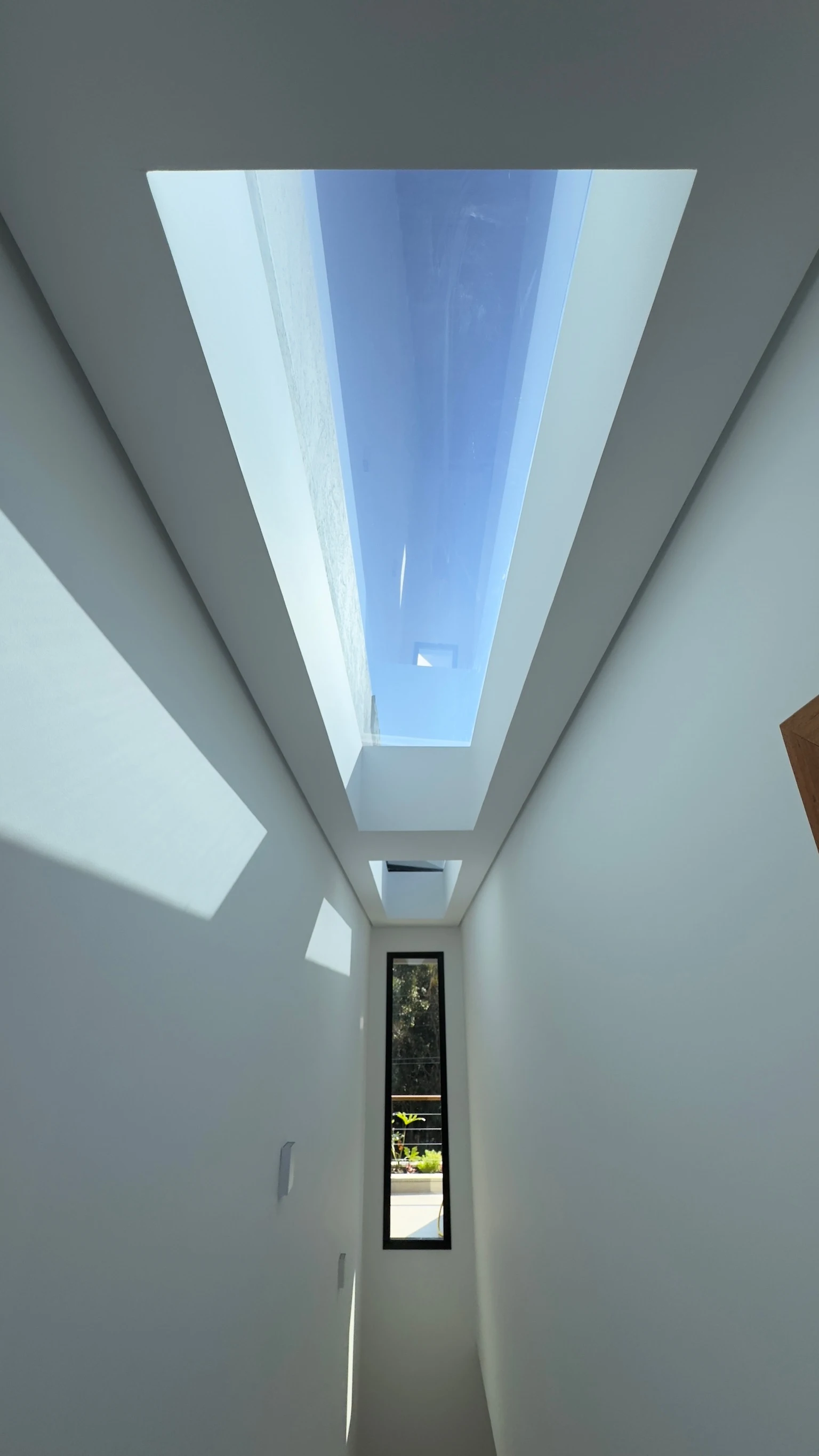 Corredor banhado pela luz natural de clarabóia linear