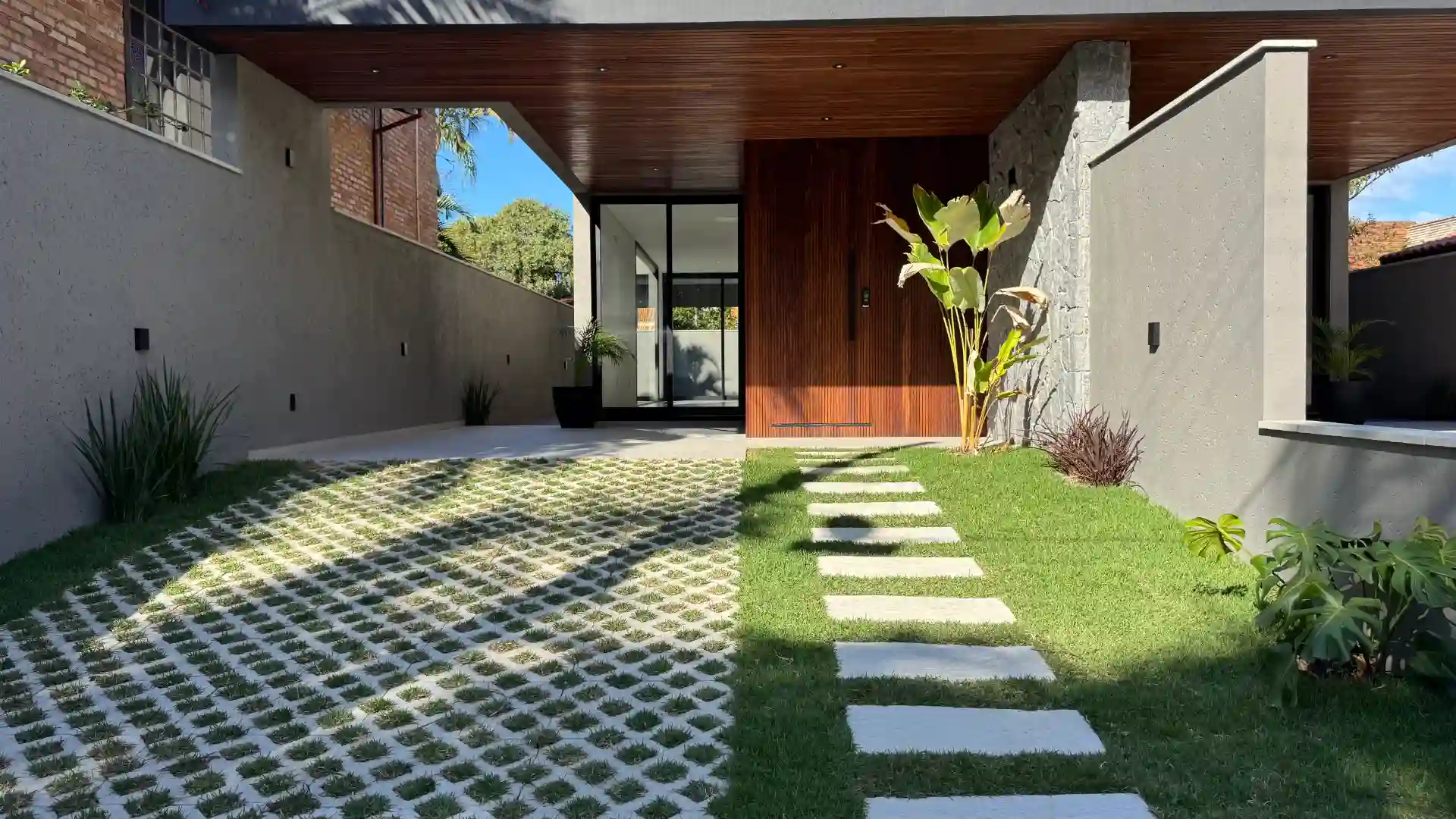 Covered parking bay beside the timber-lined entrance and concrete garden path