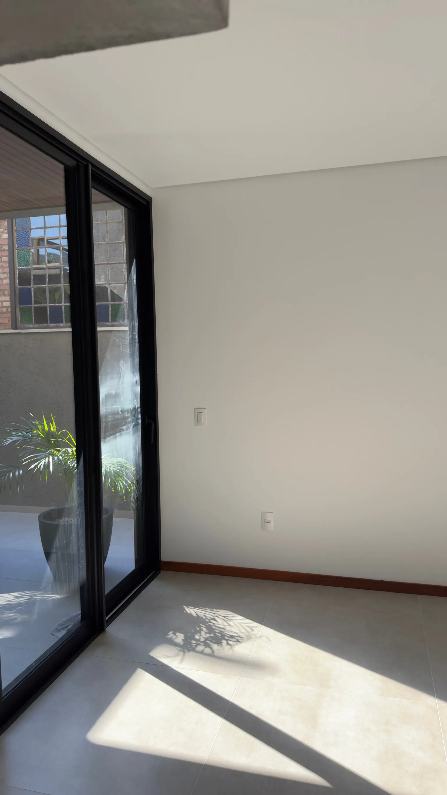 Porta de vidro que abre para o pátio interior ajardinado