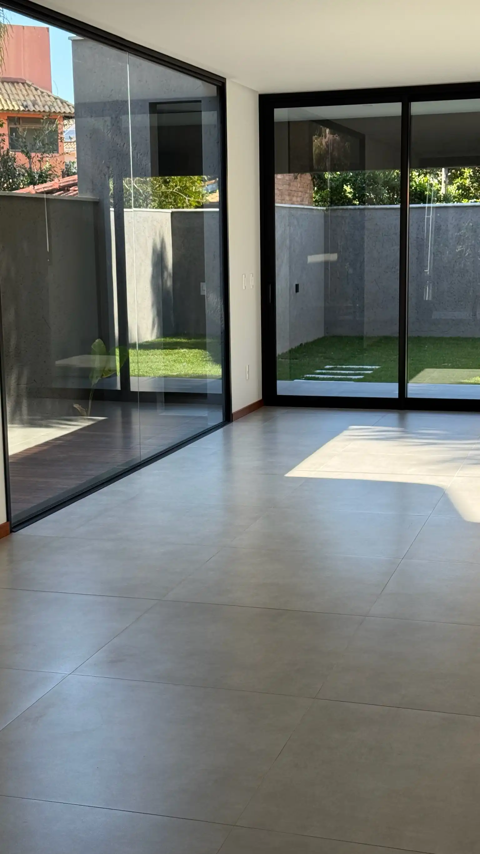 Sala de estar com portas de correr em vidro para o pátio interior