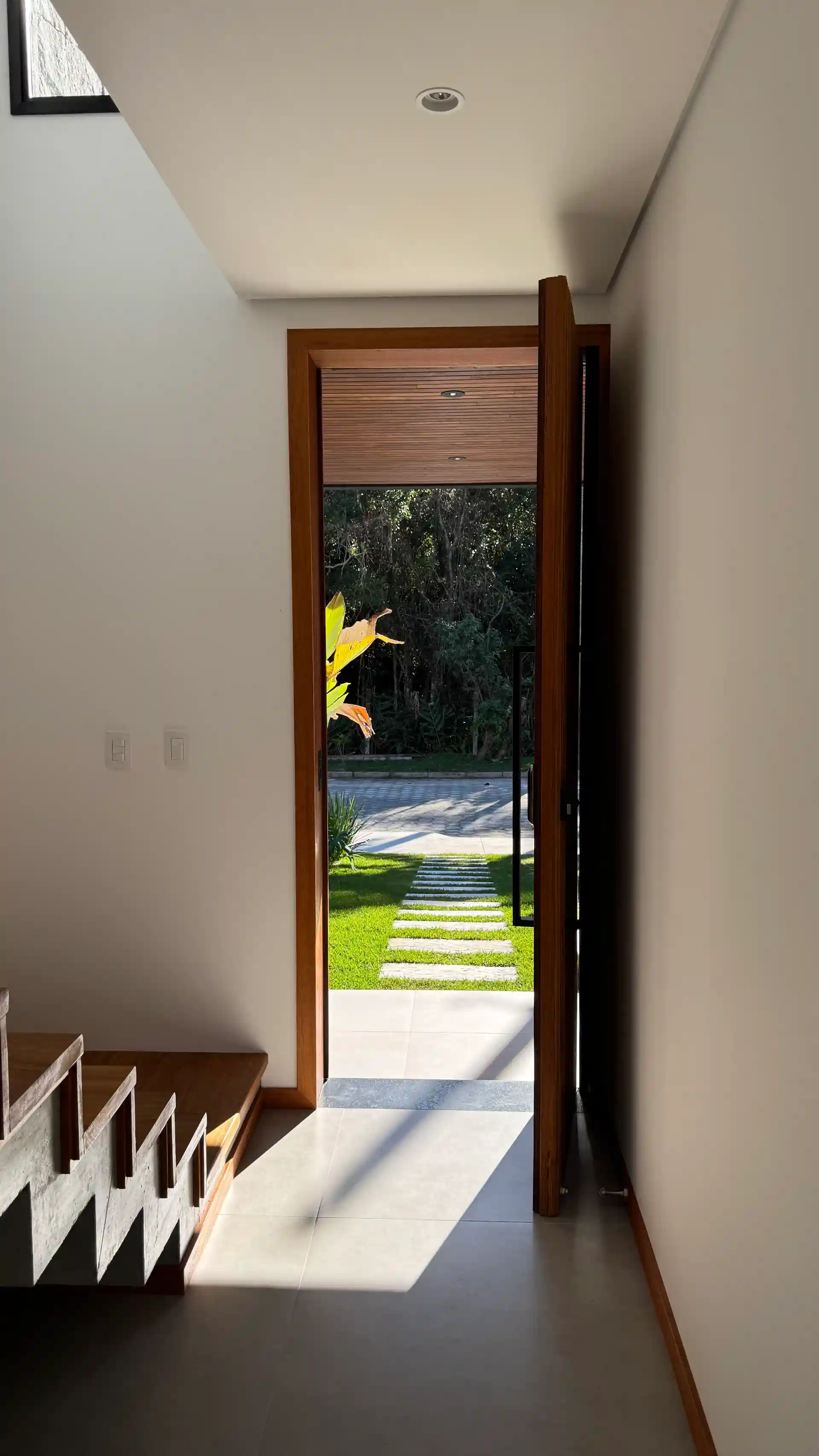 View from the entrance hall through the open timber door to the front garden path